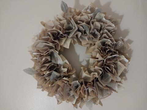 Wreath made out of crinkled book pages that have been dipped in silver and glitter.