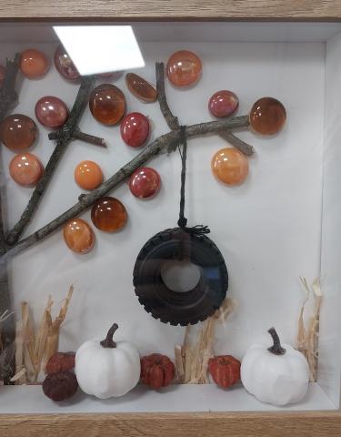 3D Autumn scene, with a tree made of sticks and orange stones. A tire swing is tied to the branch and mini orange and white pumpkins sit at the base of the scene. 