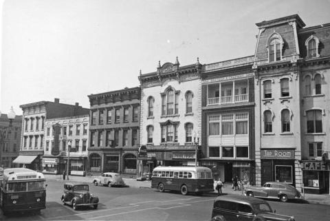 Black and white photograph of buildings and vehicles on Glen Street in 1943.