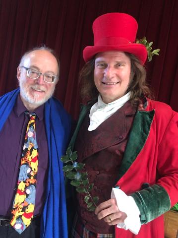 Jonathan Kruk in a festive red costume, posing alongside his accompanist, Tom McCoy