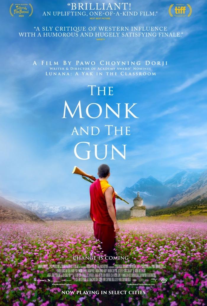 Monk in red robe standing in a field of flowers